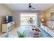 Well-lit living room featuring stylish furniture, ceiling fan, and a sliding door to the outdoors at 26333 Nadir Rd # 111, Punta Gorda, FL 33983