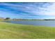 Scenic pond view on a sunny day featuring well-manicured green grass and clear skies at 26333 Nadir Rd # 111, Punta Gorda, FL 33983