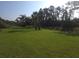 Expansive backyard with a lush green lawn and mature trees, offering privacy and a serene outdoor space at 2739 Sherman Oak Dr, North Port, FL 34289