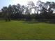 Expansive backyard with a lush green lawn and mature trees, offering privacy and a serene outdoor space at 2739 Sherman Oak Dr, North Port, FL 34289