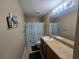 Bathroom featuring a cultured marble vanity top, framed mirror and decorative leaf shower curtain at 2739 Sherman Oak Dr, North Port, FL 34289