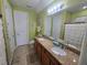 Bathroom with double sinks, granite countertop, tile floors, and a full mirror at 2739 Sherman Oak Dr, North Port, FL 34289