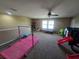 Spacious bonus room with a ceiling fan, carpet, and a variety of play equipment at 2739 Sherman Oak Dr, North Port, FL 34289