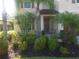 Charming home with lush landscaping, including tropical plants, shrubs, and flowers, creating a serene curb appeal at 2739 Sherman Oak Dr, North Port, FL 34289