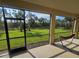 A relaxing lanai view with a hammock overlooking a lush green lawn and mature palm trees at 2739 Sherman Oak Dr, North Port, FL 34289