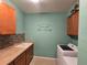 Functional laundry room with upper cabinets, mosaic backsplash and a front load washer and dryer at 2739 Sherman Oak Dr, North Port, FL 34289