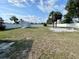 Large, fenced backyard with lush green grass, featuring a storage shed and a fire pit at 3122 Scranton St, Port Charlotte, FL 33952
