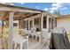 Covered wooden deck with white outdoor furniture and a grill at 315 Holly Rd, Venice, FL 34293