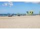 A vibrant beach scene with a lifeguard station and people enjoying the sand and surf at 315 Holly Rd, Venice, FL 34293