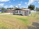 View of the home's exterior showcasing the manicured lawn and a charming, fenced-in yard at 315 Holly Rd, Venice, FL 34293