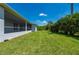 Expansive backyard with well-kept lawn and screened lanai offering seamless indoor-outdoor living at 3302 Palm Dr, Punta Gorda, FL 33950
