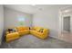 Bedroom showcasing a large yellow sectional sofa, carpet, and natural light at 3302 Palm Dr, Punta Gorda, FL 33950