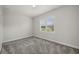 Empty bedroom featuring a large window with plantation shutters and carpet floors at 3302 Palm Dr, Punta Gorda, FL 33950