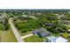 An aerial view showcases the home's manicured lawn, neighboring greenery, and a paved driveway at 3302 Palm Dr, Punta Gorda, FL 33950
