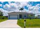 Attractive single-story home with well-maintained lawn, two-car garage, and tropical landscaping at 3302 Palm Dr, Punta Gorda, FL 33950