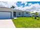 Close up of attractive single-story home featuring green lawn and two-car garage at 3302 Palm Dr, Punta Gorda, FL 33950