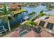 Waterfront home featuring a screened-in pool, a boat lift, and lush tropical surroundings at 3353 Sandpiper Dr, Punta Gorda, FL 33950