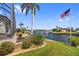 The home has a meticulously landscaped backyard along a canal with a private dock and an American flag at 3353 Sandpiper Dr, Punta Gorda, FL 33950