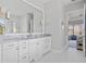 Bathroom features a marble countertop, double vanity, and a large mirror with decorative lighting at 3353 Sandpiper Dr, Punta Gorda, FL 33950