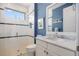 Modern bathroom with blue walls, marble countertop vanity, and glass-enclosed shower at 3353 Sandpiper Dr, Punta Gorda, FL 33950