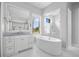 Bright bathroom features a soaking tub, walk-in shower and double vanity with a marble countertop at 3353 Sandpiper Dr, Punta Gorda, FL 33950