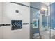 Shower and vanity with blue accent tiles and marble countertops in a contemporary bathroom at 3353 Sandpiper Dr, Punta Gorda, FL 33950