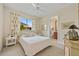 Cozy bedroom features a bright window, overhead fan, and ensuite bathroom at 3353 Sandpiper Dr, Punta Gorda, FL 33950