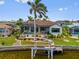 Beautiful waterfront home with a screened-in pool, boat dock, and lush tropical landscaping at 3353 Sandpiper Dr, Punta Gorda, FL 33950