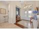 A lovely foyer features a decorative light fixture, tile flooring, and glass front doors at 3353 Sandpiper Dr, Punta Gorda, FL 33950