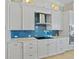 Modern kitchen boasts white cabinets, stainless steel appliances, granite countertops, and blue backsplash at 3353 Sandpiper Dr, Punta Gorda, FL 33950