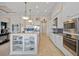 Open kitchen featuring stainless steel appliances, a large island with storage, and white cabinetry with blue backsplash at 3353 Sandpiper Dr, Punta Gorda, FL 33950