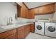 Well-organized laundry room featuring ample cabinetry, a sink, and a full-size washer and dryer set at 3353 Sandpiper Dr, Punta Gorda, FL 33950
