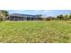 Spacious grassy backyard offering ample room for recreation, complemented by a screened-in lanai at 336 Waterside St, Port Charlotte, FL 33954