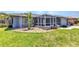 Well-maintained home exterior showcasing a screened-in lanai, rock garden, and green lawn at 336 Waterside St, Port Charlotte, FL 33954