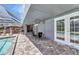 Outdoor patio with poolside dining, ceiling fan, and double doors provides seamless indoor-outdoor living at 336 Waterside St, Port Charlotte, FL 33954