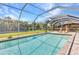 Screened in pool with lounge chairs, dining table and lush landscaping creates a perfect outdoor oasis at 336 Waterside St, Port Charlotte, FL 33954