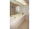 Well-lit bathroom featuring double sinks, shuttered window and floral wallpaper at 3398 Tripoli Blvd, Punta Gorda, FL 33950