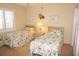 Bedroom featuring two twin beds with floral bedding and plantation shutters at 3398 Tripoli Blvd, Punta Gorda, FL 33950
