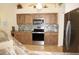 Well-lit kitchen featuring wooden cabinets, stainless steel appliances, tile backsplash, and marble countertops at 3398 Tripoli Blvd, Punta Gorda, FL 33950