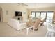 Open-concept living area featuring a large TV, comfortable seating, and pool views through sliding glass doors at 3398 Tripoli Blvd, Punta Gorda, FL 33950