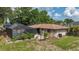 Back view of the home with a screened in pool and landscaped yard at 4071 Dekle Ave, North Port, FL 34286