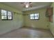Neutral bedroom features tile floors, two windows with blinds and a ceiling fan at 4071 Dekle Ave, North Port, FL 34286