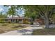 Exterior view of the house, showing the driveway and garage, with mature shade trees at 4071 Dekle Ave, North Port, FL 34286