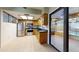 Kitchen showcasing stainless steel appliances, wooden cabinets, tiled flooring, and access to outdoor lanai at 4071 Dekle Ave, North Port, FL 34286