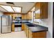 Well-lit kitchen featuring wooden cabinets, stainless steel appliances, tile flooring, and neutral decor at 4071 Dekle Ave, North Port, FL 34286