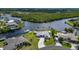 Panoramic aerial view of a waterfront home surrounded by lush greenery and waterways, with a neatly kept lawn at 4216 Bur St, Port Charlotte, FL 33948