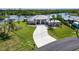Aerial view of property with a spacious lawn, long driveway, and waterfront views of the canal at 4216 Bur St, Port Charlotte, FL 33948