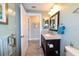 A well-lit bathroom with a wood vanity, marble countertop, and modern fixtures at 4216 Bur St, Port Charlotte, FL 33948