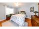 Light-filled bedroom with hardwood floors, a ceiling fan, and a cozy bed with tropical-themed bedding at 4216 Bur St, Port Charlotte, FL 33948