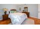 Light-filled bedroom with hardwood floors, a ceiling fan, and a cozy bed with tropical-themed bedding at 4216 Bur St, Port Charlotte, FL 33948